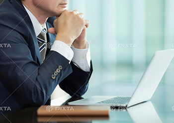 PCの前で思案する人